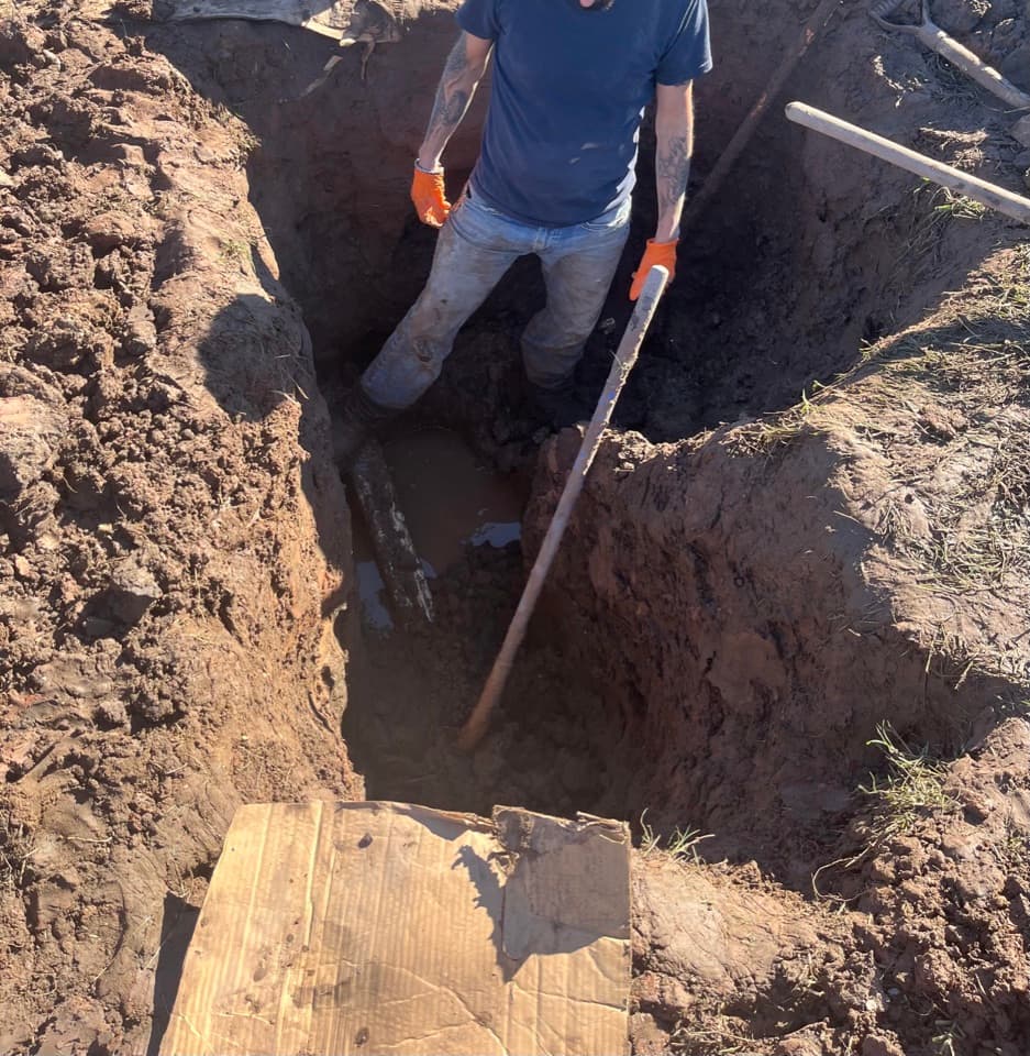 Wilson Plumbing technician working inside an excavated trench